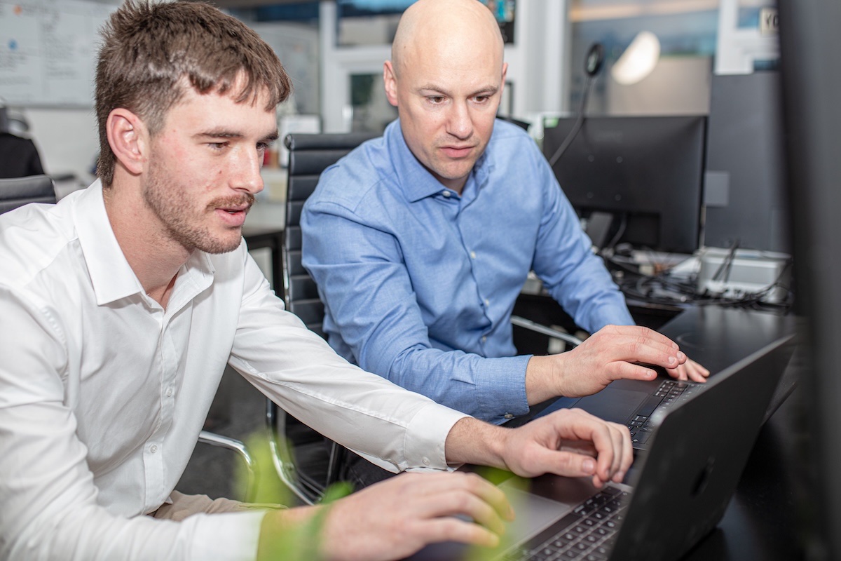 David and Luke from Halizona working together at laptops in the office